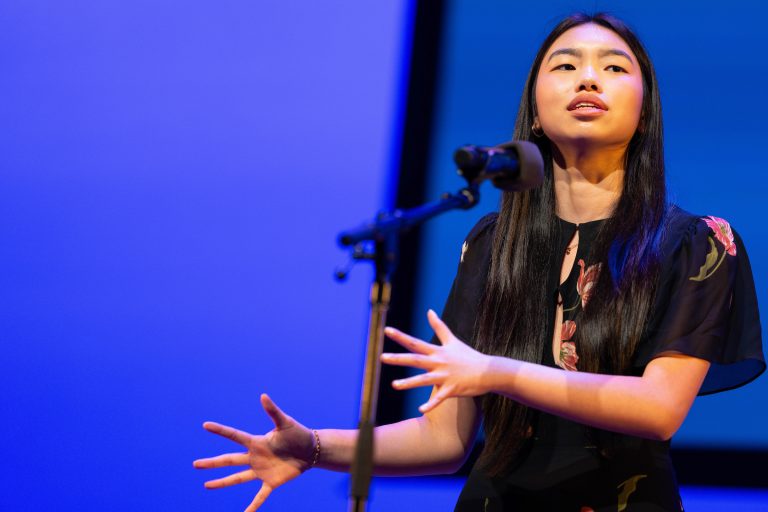 A student recites onstage.